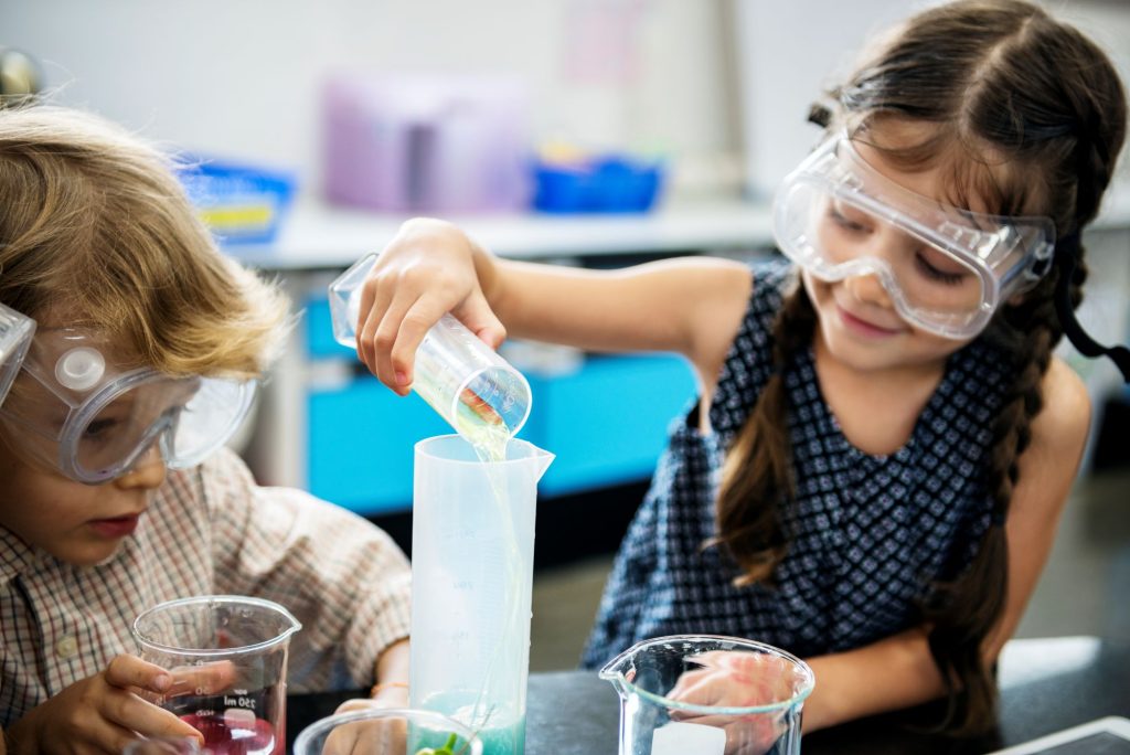 enfant réalisant une expérience de chimie en cours de science à l'école primaire